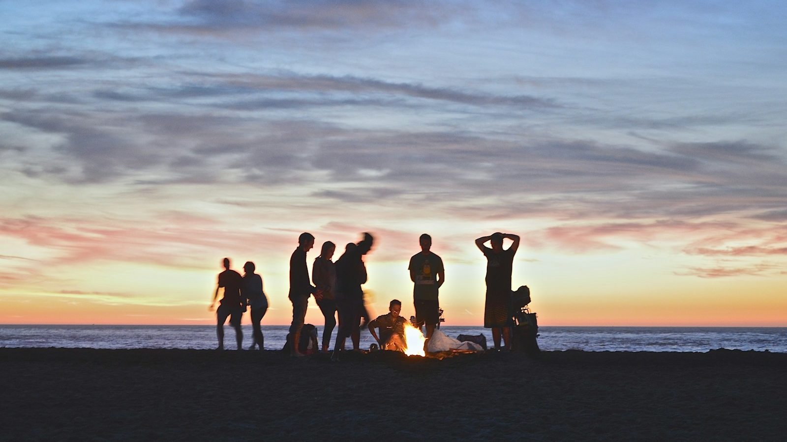 group of people setting up campfire