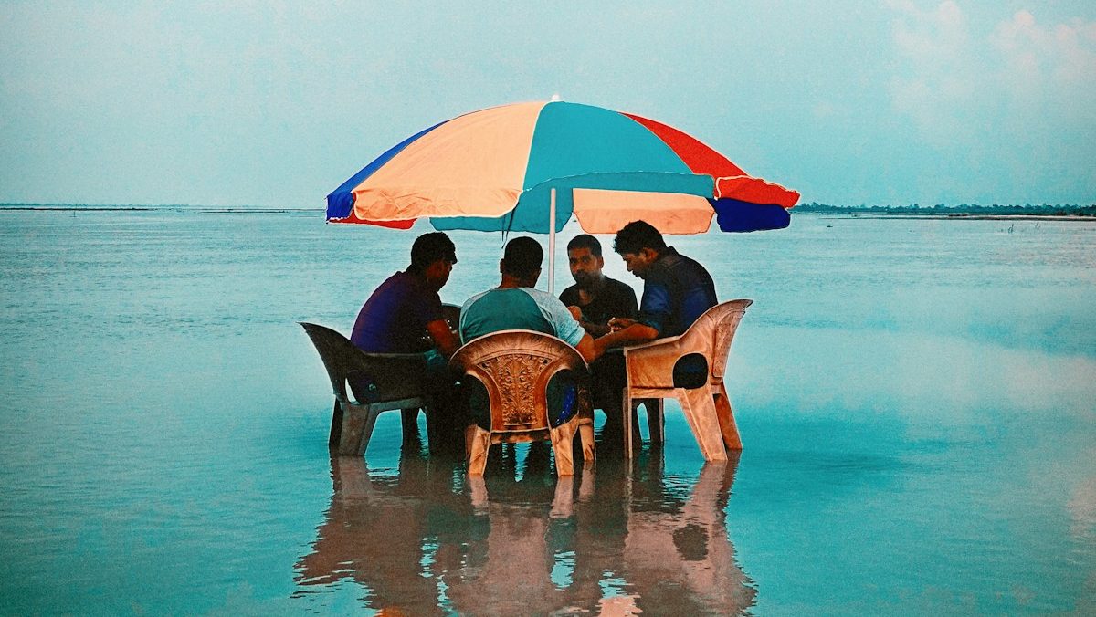 people sitting on beach chairs under blue sky during daytime
